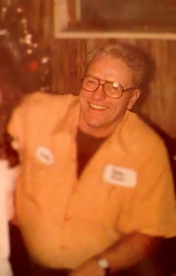 Smiling man in yellow shirt with glasses, representing a legacy of honest service in HVAC, reflecting family-owned values at Kelly’s Heating and Air.