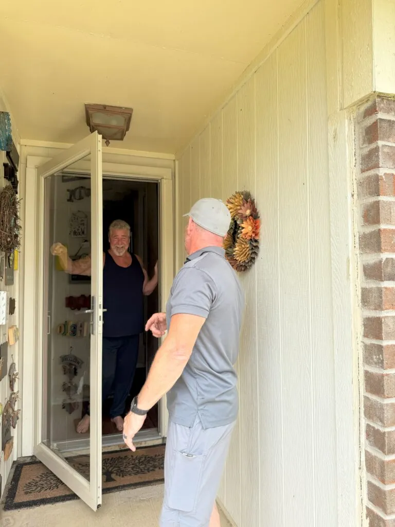 Home visit: Technician arrives at a customer's home in Lewisville, TX, for a service appointment. Smiling homeowner welcomes the technician.
