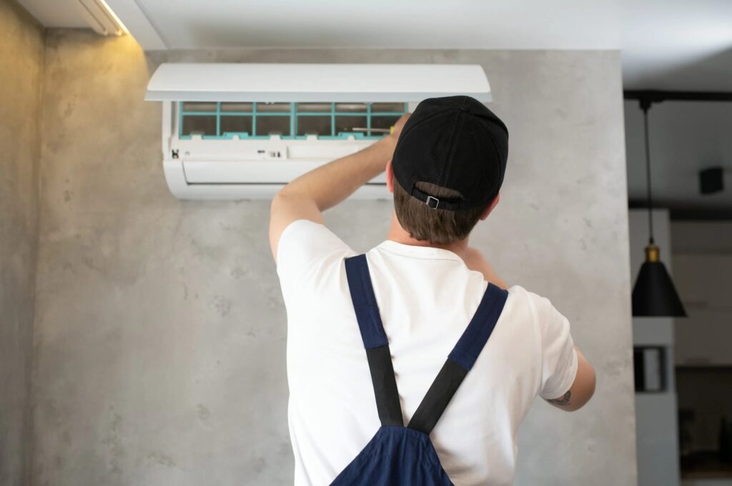 Serviceman repairs ductless mini-split in Lewisville, TX. Professional AC installation and maintenance for efficient home cooling.