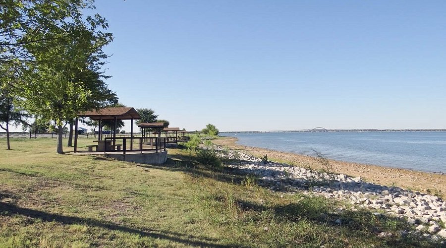 Lake scene with picnic pavilions and ductless mini-split installation potential in Lewisville, TX. Serene waterfront view.